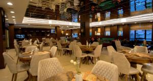 a dining room with tables and chairs in a restaurant at Andalus Habitat Hotel in Jeddah