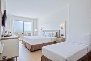 a hotel room with two beds and a balcony at Melia Sitges in Sitges