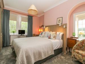Un dormitorio con una cama grande y un televisor. en The Stone Masons House, en Keighley