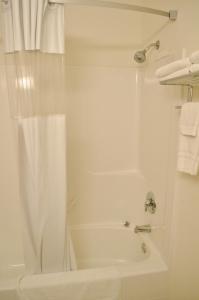 y baño con bañera y ducha con cortina de ducha. en Knights Inn Quincy en Quincy