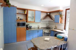 eine Küche mit blauen Schränken und einem Tisch mit Stühlen in der Unterkunft Casamary Planta Alta in Pontevedra