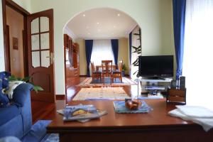 ein Wohnzimmer mit einem Tisch und einem TV in der Unterkunft Casamary Planta Alta in Pontevedra