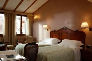 a hotel room with two beds and a table and chairs at Hotel Bisanzio in Venice