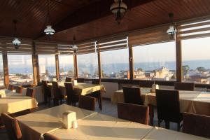 イスタンブールにあるグランド リザ ホテルのテーブルと椅子、大きな窓のあるレストラン