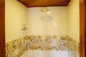 uma casa de banho com chuveiro e azulejos na parede em Pousada Refúgio das Aves em Visconde de Mauá