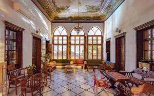duży pokój ze stołami, krzesłami i oknami w obiekcie Fauzi Azar by Abraham w mieście Nazaret