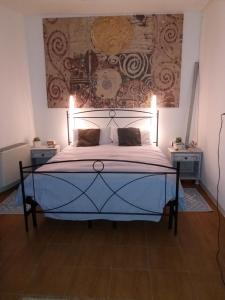 una camera da letto con un letto e un dipinto sul muro di Lughera b&b a Tula