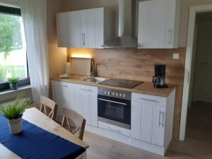 a kitchen with white cabinets and a sink and a table at Hibbeln Hof in Brilon