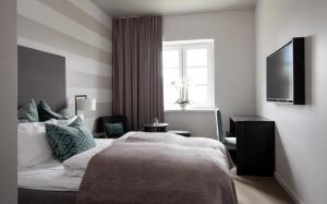 um quarto com uma cama, uma janela e uma televisão em Wilhelmsen House em Tønsberg
