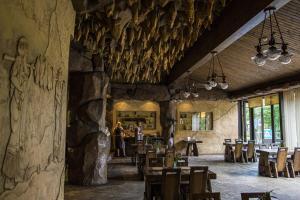 ein Esszimmer mit Tischen und Stühlen und einer Steinmauer in der Unterkunft Vila Romnesa in Ignalina