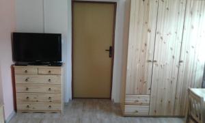 a room with a door and a television on a dresser at České Švýcarsko - Apartmán pro 2-3 dospělé osoby in Srbská Kamenice