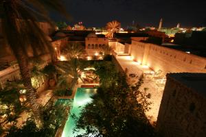 - une vue sur la piscine la nuit dans l'établissement DAR NEJMA, à Tozeur