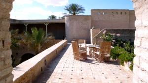 a patio with a table and chairs and a building at DAR NEJMA in Tozeur