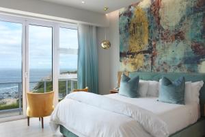 a bedroom with a large bed and a large window at Hermanus Boutique Guest House in Hermanus