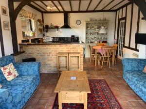 uma sala de estar com dois sofás azuis e uma mesa em Rose Cottage em Rye