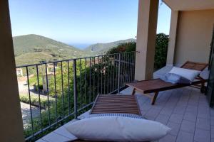 balcón con mesa y vistas al océano en Magic Elba & Mindfulness Apartment en Rio nellʼElba
