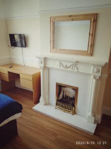 a room with a fireplace with a mirror and a desk at BSL - Filton in Bristol