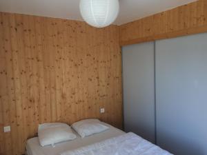 a bedroom with wooden walls and a bed with two pillows at Grand appartement 130m2 à 5mn des stations de ski in Formiguères