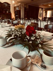 een tafel met een boeket bloemen en bekers erop bij Hotel Restaurante Santa Lucía in La Magdalena