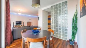 a dining room and kitchen with a table and chairs at Apartamenty Sun & Snow Szafarnia in Gdańsk