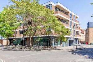 a large building with a tree in front of it at A'nB Oxford LUX 2-Bedroom plus private parking 5-STAR Central OX1 in Oxford