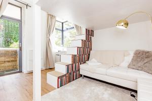 a living room with a white couch and bookshelves at A'nB Oxford LUX 2-Bedroom plus private parking 5-STAR Central OX1 in Oxford