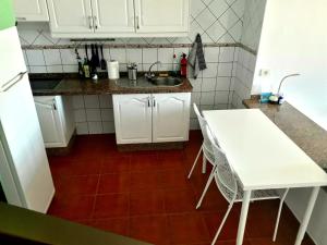 a kitchen with a white table and a sink at casa mariposa in Playa de Santiago