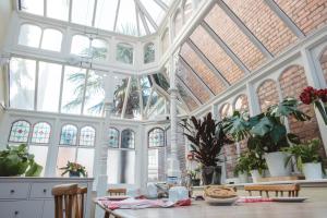 a large conservatory with a table and some plants at Ashburton Court Guest House in Ashburton +23 photos