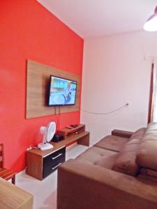 a living room with a bed and a flat screen tv at Casa Vila Dom Pedro in Paraty