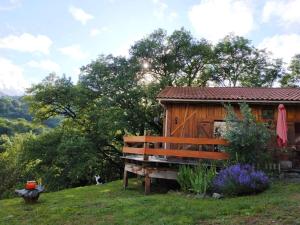 a bench sitting next to a wooden cabin at Le Refuge De L'Ourse in Anla