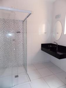 a bathroom with a glass shower and a sink at Casa Vila Dom Pedro in Paraty