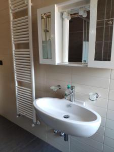 bagno con lavandino bianco e specchio di Residenza Adriatica 1 a Roseto degli Abruzzi