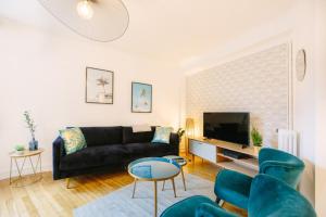 Una sala de estar con un sofá negro y un televisor. en L'Imperti'Nantes- T3bis de Standing, en Nantes