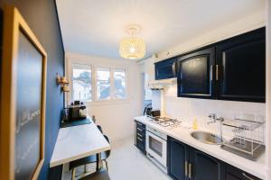 Una cocina con gabinetes azules y un fregadero. en L'Imperti'Nantes- T3bis de Standing, en Nantes 18 fotos más