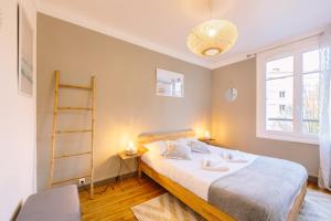 Un dormitorio con una cama grande y una ventana. en L'Imperti'Nantes- T3bis de Standing, en Nantes