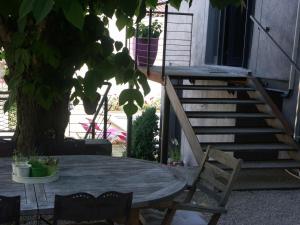 une table et des chaises dans une cour avec un arbre dans l'établissement Maison d'Hôtes Côté Cour, à Rasteau