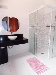 a bathroom with a sink and a shower with a mirror at Casa Vila Dom Pedro in Paraty