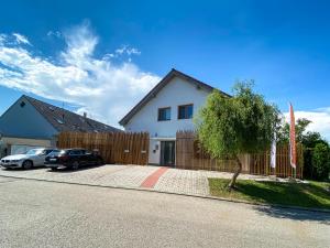 a house with two cars parked in front of it at Modern fully equipped studio with parking Zavadilka 2620 in České Budějovice