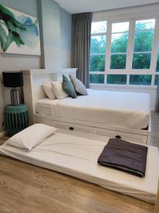 two twin beds in a room with a window at 2 Bedroom Summer Huahin Condominium in Hua Hin