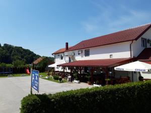 a building with a sign in front of it at SOBE RIM BREZJE DRAVSKO in Cestica