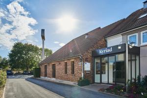 akritkrit store in a brick building on a street at Kyriad Paris Sud Les Ulis Courtaboeuf in Les Ulis