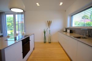 a kitchen with white counters and a sink and a window at Max White Apartments in Leegebruch