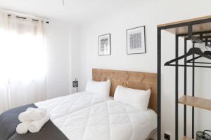 a bedroom with a white bed with a stuffed animal on it at Town Hall in Bilbao