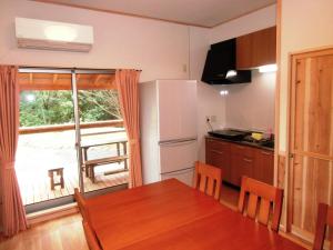 a kitchen with a table and a large window at Guest House Yakushima in Yakushima