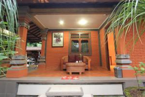 a living room with a couch on a patio at Duana's Homestay in Ubud