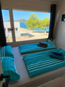 2 łóżka w pokoju z widokiem na plażę w obiekcie Camp BUQEZ Villa 30 "Beachvilla Stella" SPA, 2BR, Seaview w mieście Drage