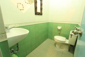 a bathroom with a white toilet and a sink at Duana's Homestay in Ubud