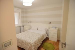 una piccola camera con un letto bianco e un tappeto verde di Apartamento Vigo Centro con Garaje a Vigo