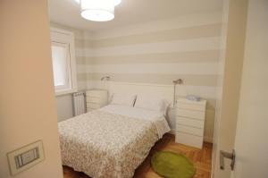 a small bedroom with a white bed and a green rug at Apartamento Vigo Centro con Garaje in Vigo