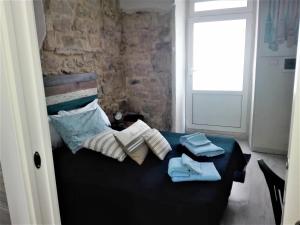 een slaapkamer met een zwart bed en handdoeken bij Only for two Giumbabulla in Ragusa